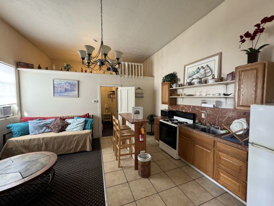 Room 1 of hotel living area with couch and kitchen space